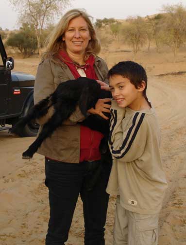 Eileen and David holding a baby goat.